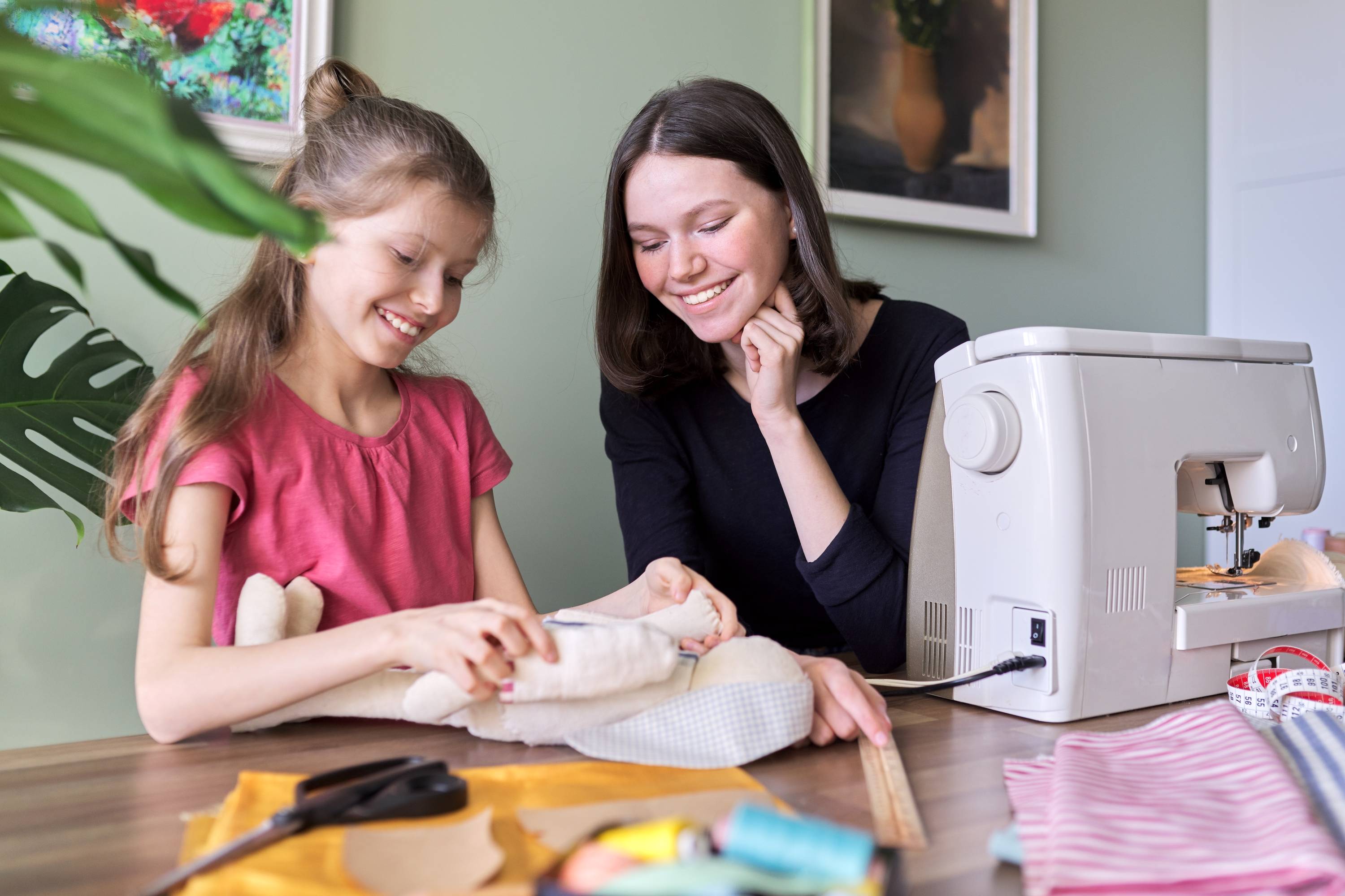 A mother and daughter sewing together.